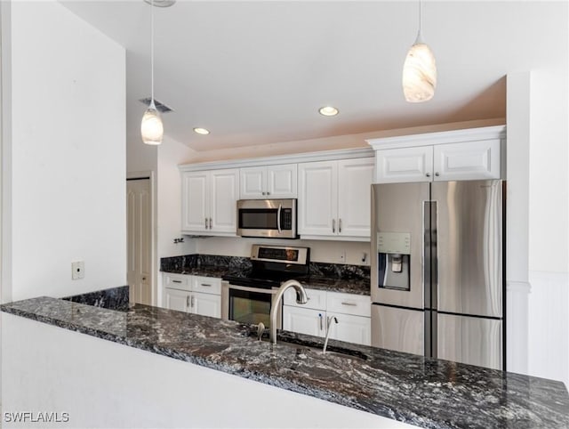 kitchen featuring white cabinetry, appliances with stainless steel finishes, dark stone countertops, and pendant lighting