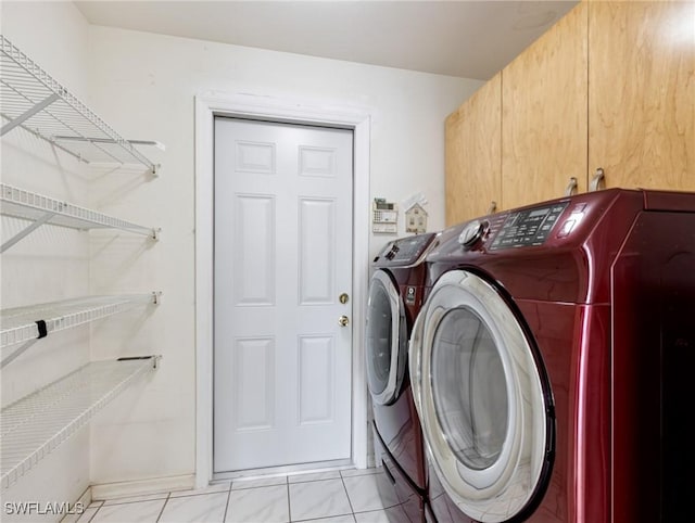 clothes washing area with cabinets and independent washer and dryer