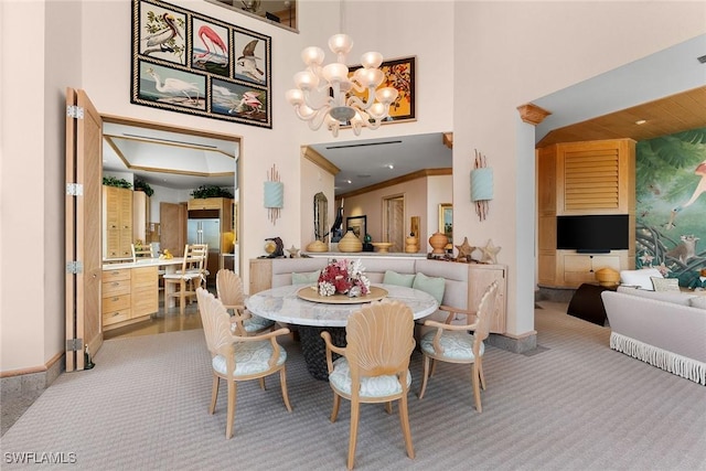 dining area with light colored carpet, a notable chandelier, and a towering ceiling