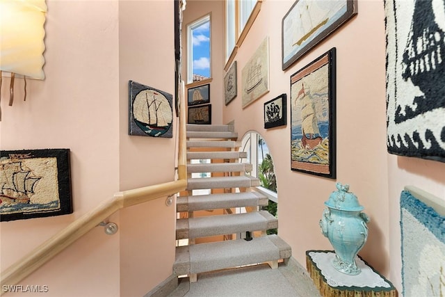 staircase featuring a high ceiling and carpet floors