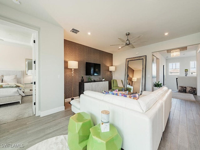 living room with light hardwood / wood-style floors and ceiling fan