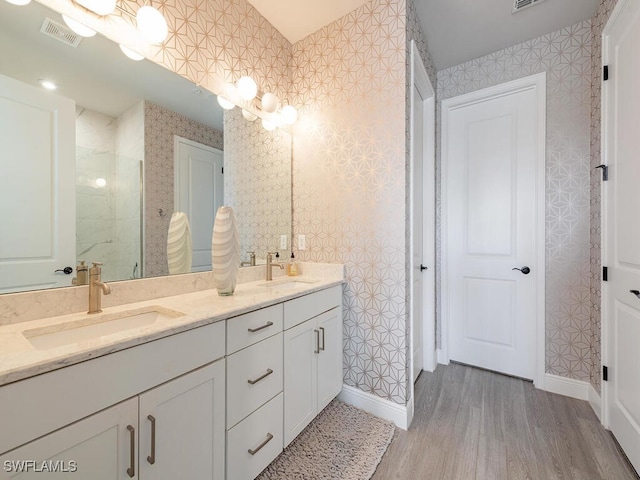 bathroom with wood-type flooring, vanity, and a shower