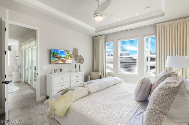 carpeted bedroom featuring crown molding, a tray ceiling, and ceiling fan