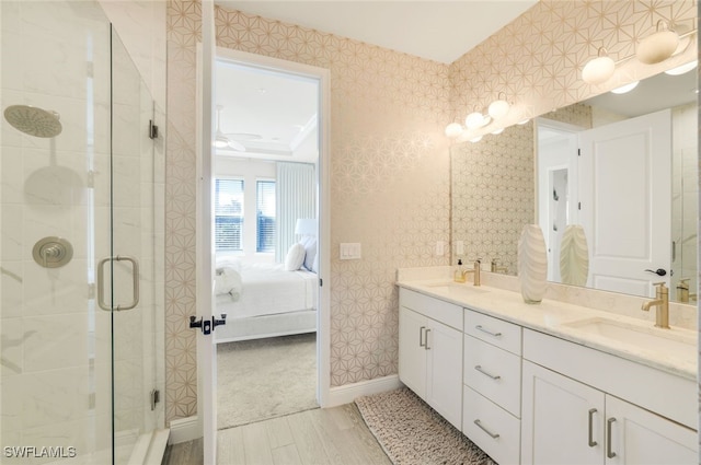 bathroom with hardwood / wood-style flooring, ceiling fan, vanity, and an enclosed shower