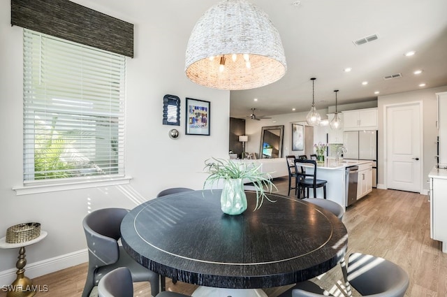 dining space with sink and light hardwood / wood-style floors