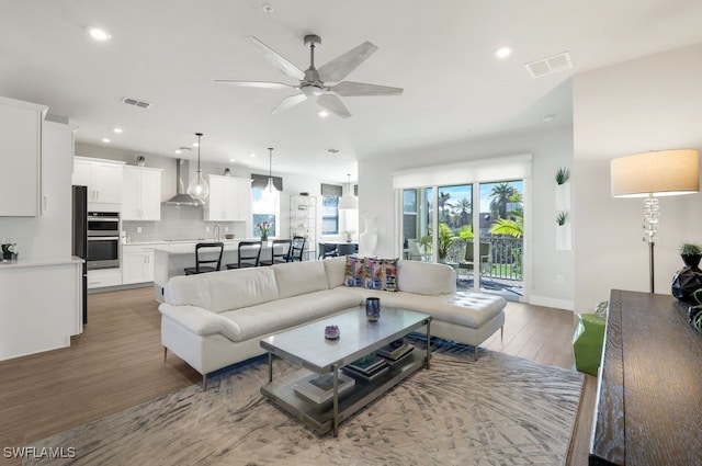 living room with hardwood / wood-style flooring, a healthy amount of sunlight, and ceiling fan