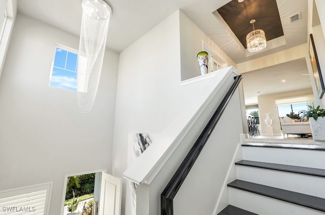 staircase featuring an inviting chandelier