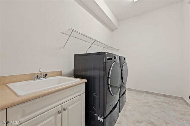 washroom featuring sink, washer and clothes dryer, and cabinets