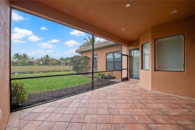 unfurnished sunroom with a water view