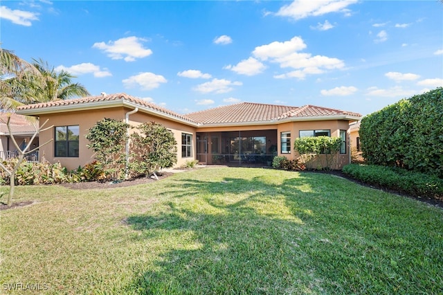 back of property featuring a sunroom and a yard