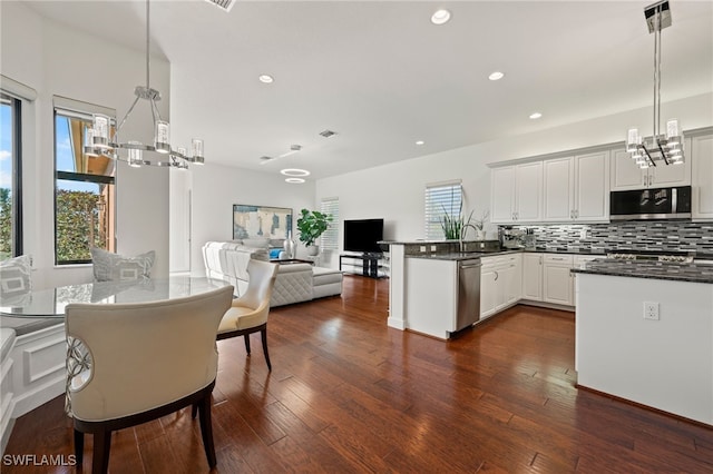 kitchen with pendant lighting, backsplash, white cabinetry, and stainless steel appliances