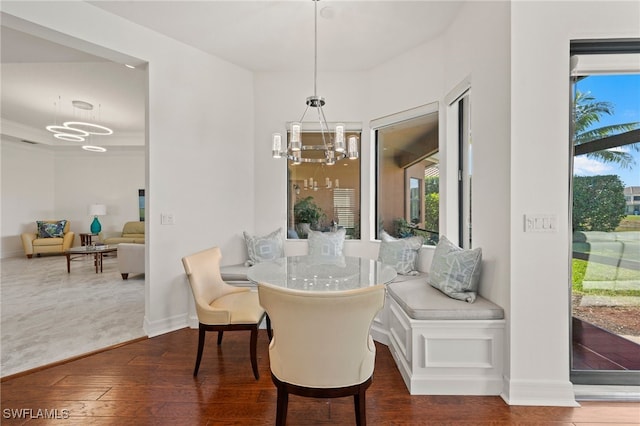 dining area featuring dark wood-type flooring and a notable chandelier