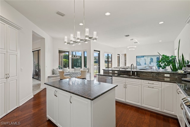 kitchen with dishwasher, sink, white cabinets, and dark stone counters