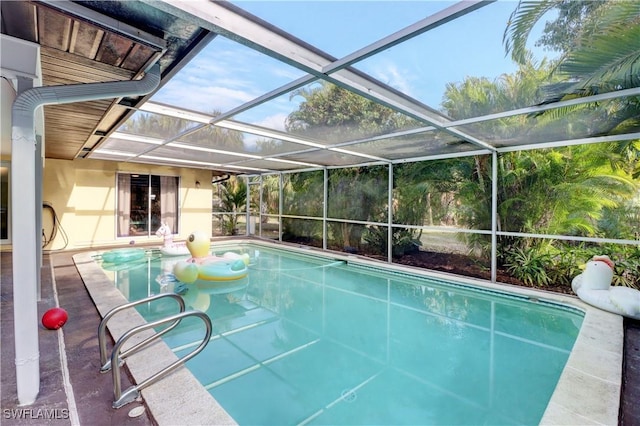 view of swimming pool featuring a lanai and a patio