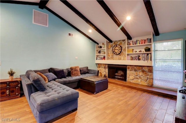 living room featuring a stone fireplace, light hardwood / wood-style flooring, and vaulted ceiling with beams