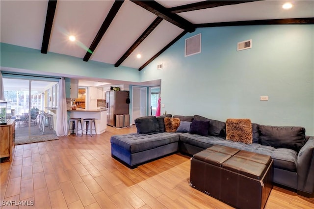 living room featuring beam ceiling, high vaulted ceiling, and light hardwood / wood-style flooring