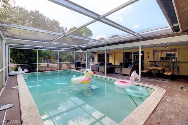 view of swimming pool featuring a patio, an outdoor hangout area, and glass enclosure