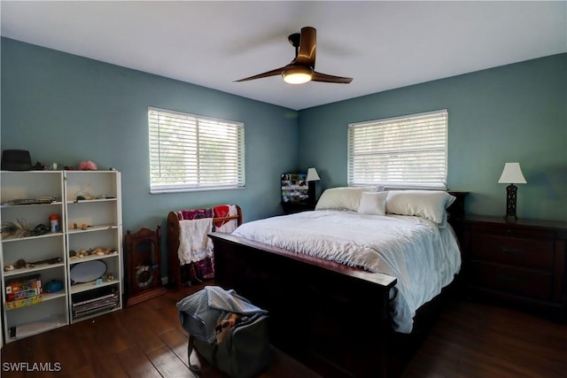 bedroom with ceiling fan, dark hardwood / wood-style flooring, and multiple windows