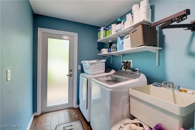 laundry room with sink, hardwood / wood-style floors, and washer and clothes dryer