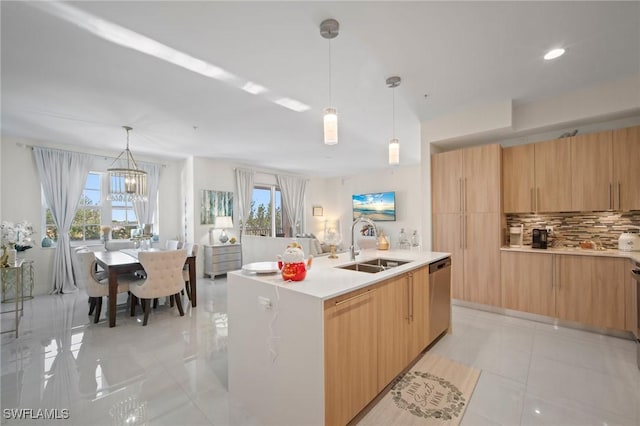 kitchen with tasteful backsplash, dishwasher, sink, hanging light fixtures, and a center island with sink