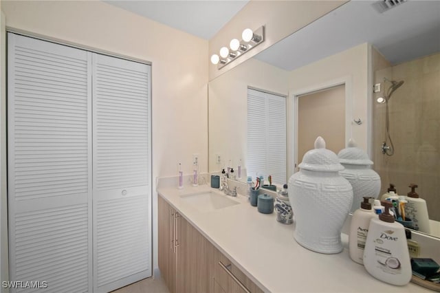 bathroom with vanity and a tile shower