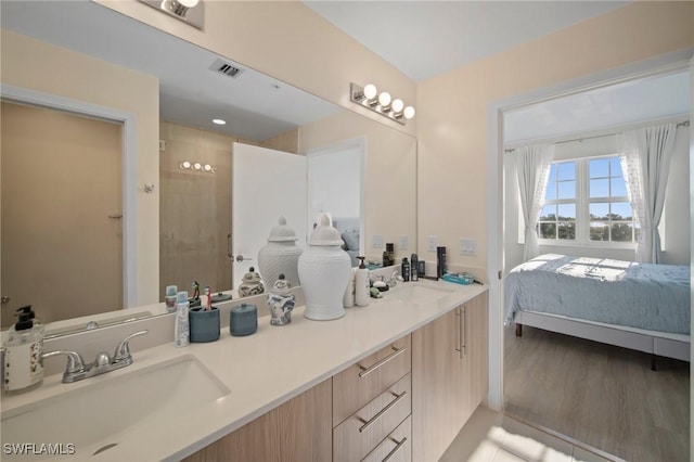 bathroom featuring hardwood / wood-style flooring, vanity, and a shower