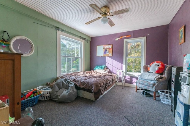 bedroom with multiple windows, ceiling fan, and carpet flooring