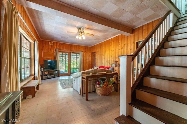 living room featuring wooden walls and ceiling fan