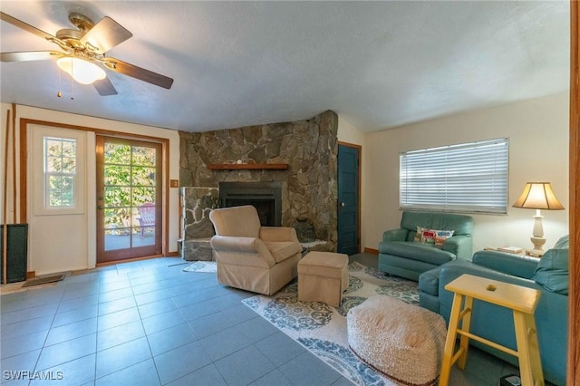 living room featuring vaulted ceiling, light tile patterned floors, a textured ceiling, and a fireplace