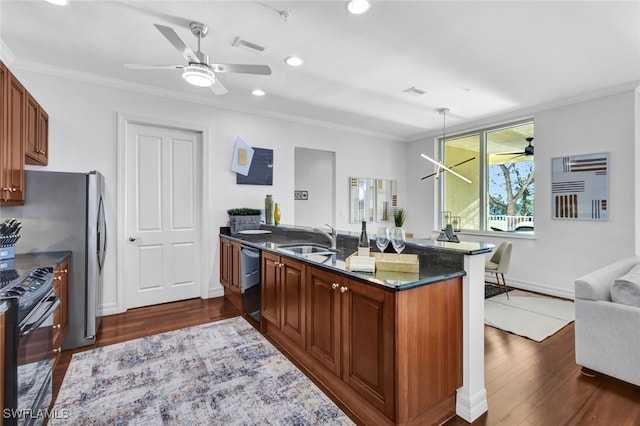 kitchen with pendant lighting, sink, dishwashing machine, dark stone counters, and black range