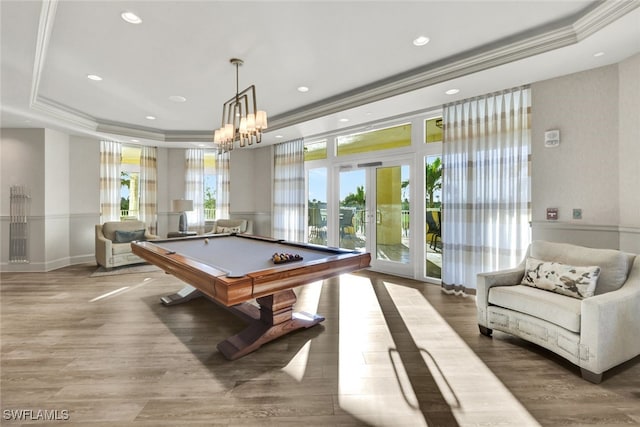 game room with pool table, wood-type flooring, ornamental molding, and a raised ceiling