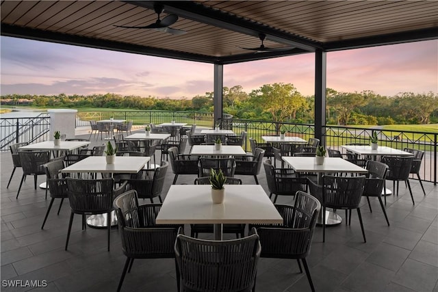 patio terrace at dusk featuring ceiling fan