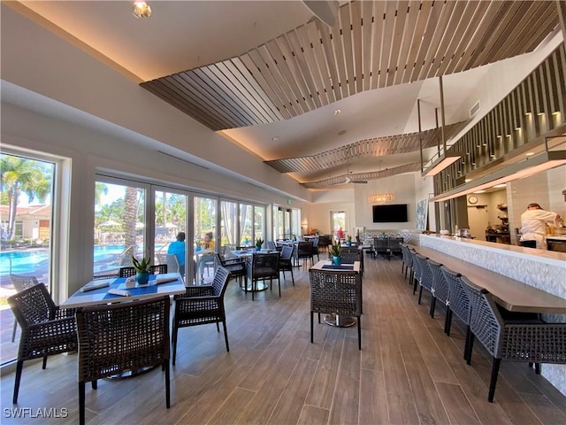 dining room featuring wood-type flooring and a high ceiling