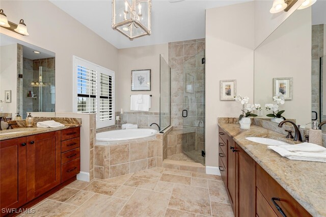 bathroom featuring a chandelier, vanity, and independent shower and bath