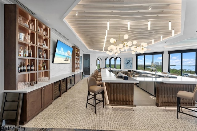 bar with a raised ceiling and a notable chandelier