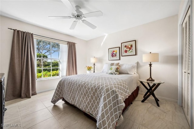 bedroom with a ceiling fan, a closet, and baseboards