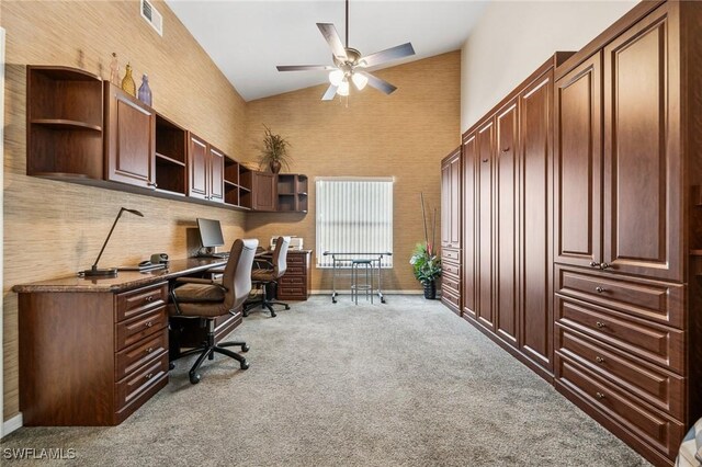 office area with high vaulted ceiling, visible vents, light carpet, and a ceiling fan