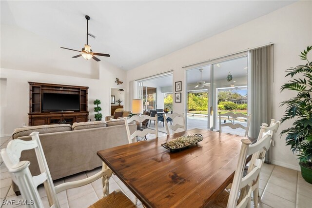 dining area with a ceiling fan, lofted ceiling, baseboards, and light tile patterned floors