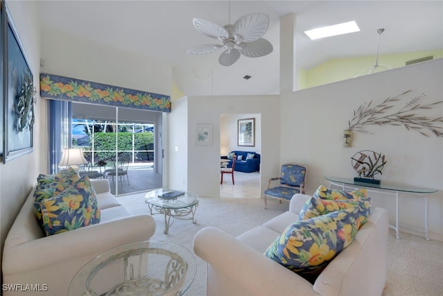 living room featuring light carpet, lofted ceiling with skylight, and ceiling fan