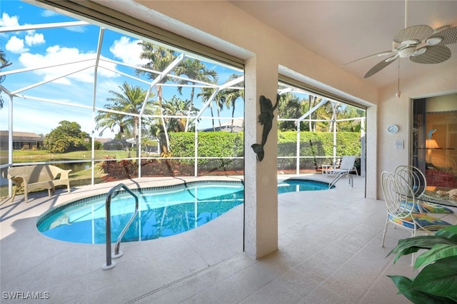 view of swimming pool with a patio, ceiling fan, and glass enclosure