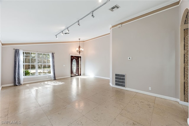 unfurnished room with ornamental molding, vaulted ceiling, track lighting, and a notable chandelier