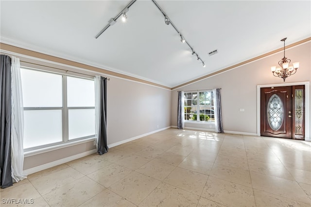 foyer entrance featuring ornamental molding, lofted ceiling, and a notable chandelier