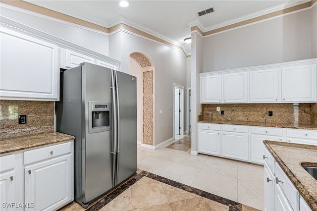 kitchen with tasteful backsplash, stainless steel fridge with ice dispenser, and white cabinets