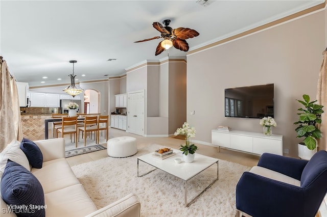 living room with ornamental molding, light tile patterned floors, and ceiling fan