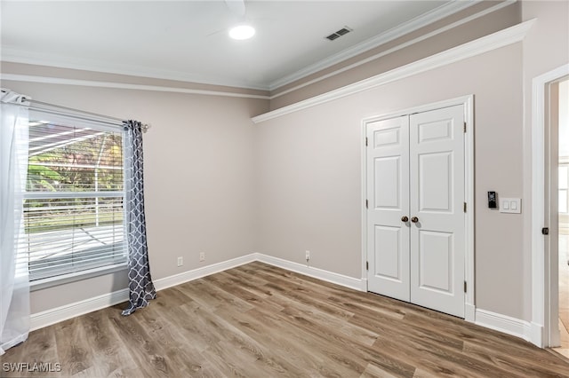 unfurnished room with hardwood / wood-style flooring and ornamental molding