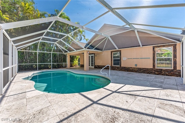 view of pool with a patio and glass enclosure