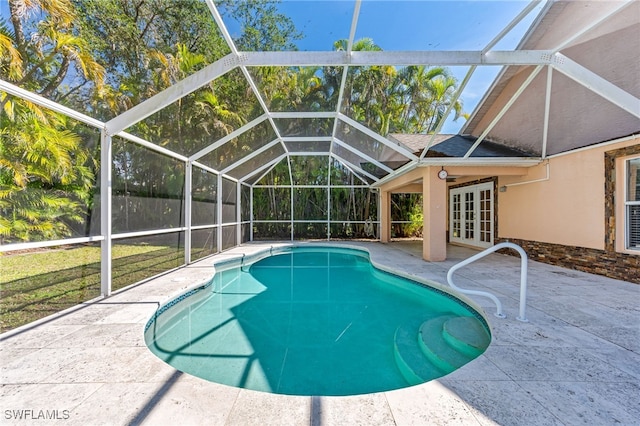 view of swimming pool with french doors, a patio, and glass enclosure