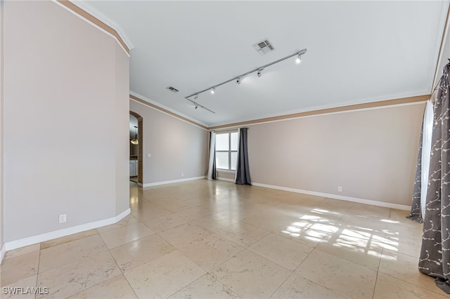 spare room with crown molding and rail lighting