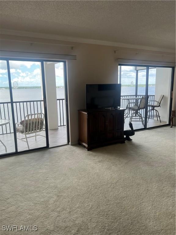 unfurnished living room with light carpet, crown molding, and a textured ceiling