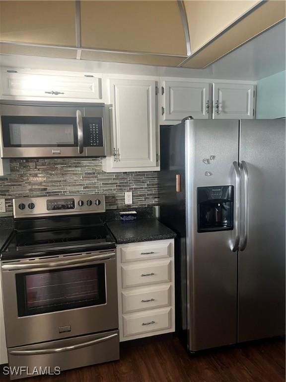 kitchen featuring white cabinetry, stainless steel appliances, dark hardwood / wood-style floors, and tasteful backsplash